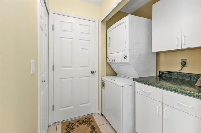 clothes washing area featuring stacked washer and dryer and light tile patterned floors