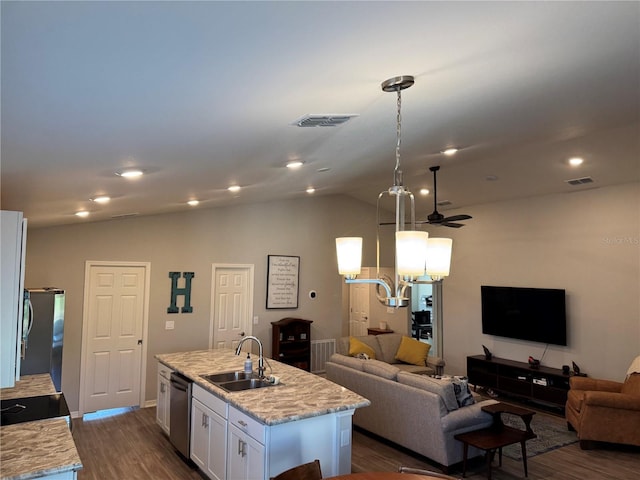 kitchen featuring light stone counters, sink, a center island with sink, white cabinetry, and hanging light fixtures