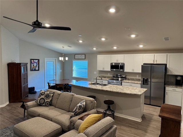 kitchen with appliances with stainless steel finishes, a kitchen island with sink, sink, decorative light fixtures, and white cabinets