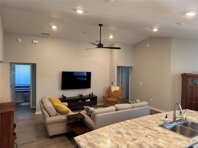 living room featuring ceiling fan, lofted ceiling, sink, and dark wood-type flooring