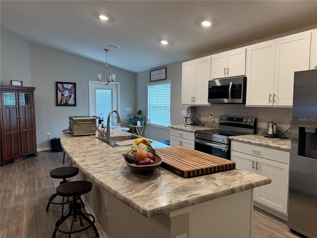 kitchen featuring a kitchen island with sink, sink, and appliances with stainless steel finishes