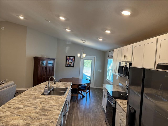 kitchen with lofted ceiling, sink, decorative light fixtures, black appliances, and white cabinets