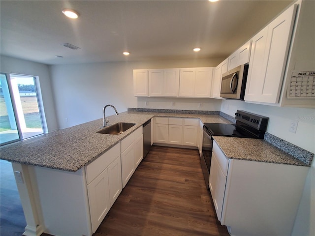 kitchen with white cabinetry, kitchen peninsula, light stone countertops, sink, and appliances with stainless steel finishes