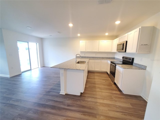 kitchen featuring white cabinetry, a center island with sink, stainless steel appliances, light stone countertops, and sink