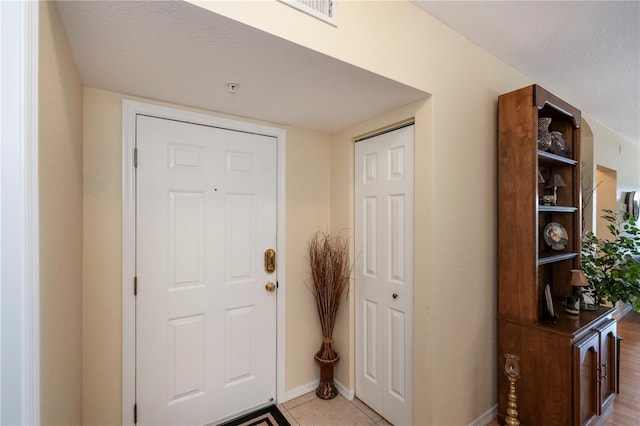 tiled foyer featuring a textured ceiling