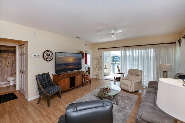 living room with light hardwood / wood-style floors and ceiling fan