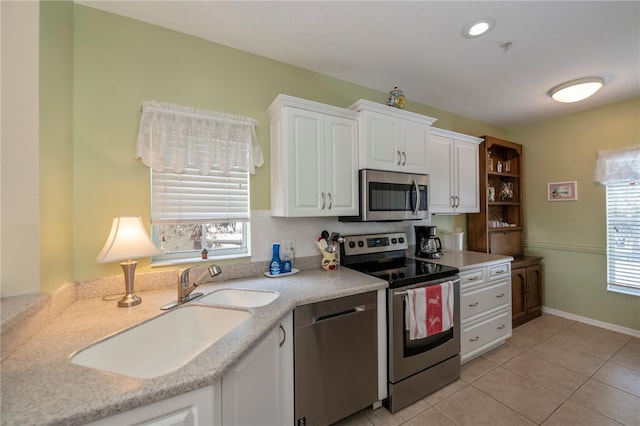 kitchen featuring a wealth of natural light, sink, white cabinetry, and stainless steel appliances