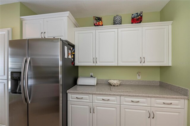 kitchen featuring stainless steel refrigerator with ice dispenser and white cabinets