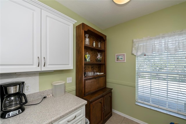 kitchen featuring white cabinetry, light tile patterned flooring, backsplash, and a textured ceiling