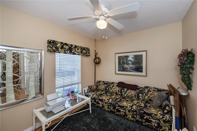 living room with a textured ceiling and ceiling fan