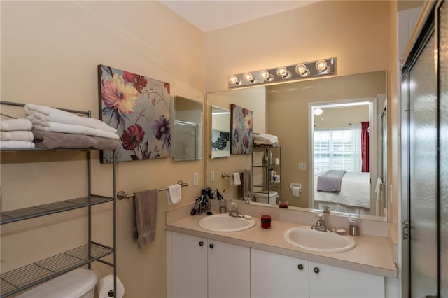 bathroom featuring toilet, vanity, and a shower with door