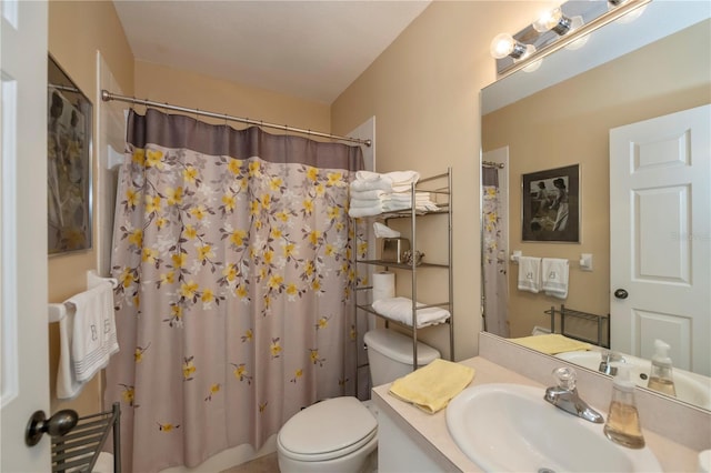 bathroom featuring vanity, toilet, and curtained shower