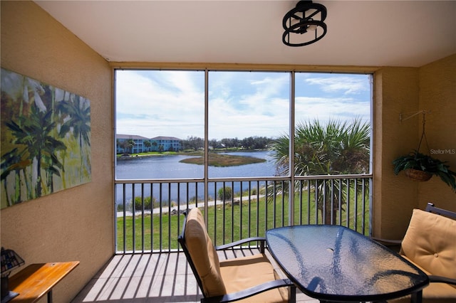 sunroom featuring a water view and plenty of natural light