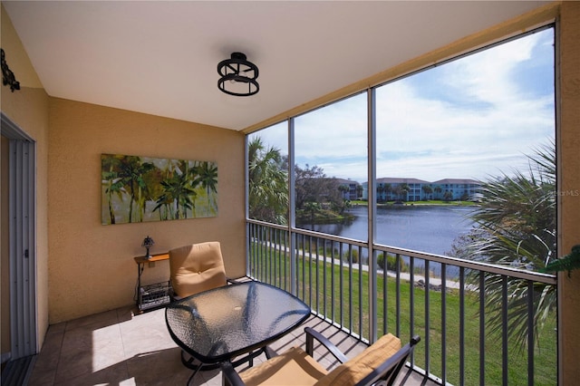 sunroom featuring a water view