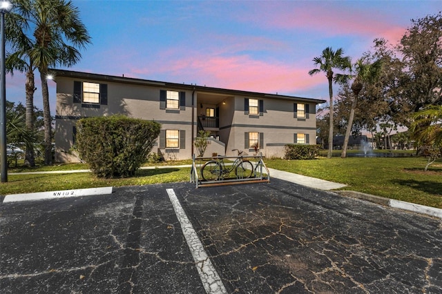 view of front of home with a lawn and a balcony