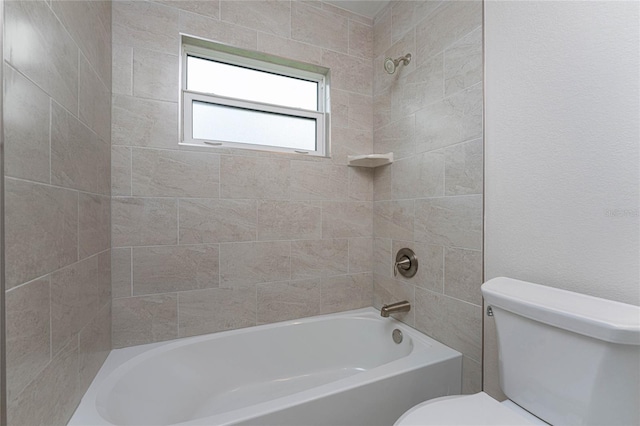 bathroom with toilet and tiled shower / bath combo