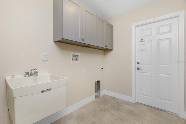 clothes washing area featuring electric dryer hookup, washer hookup, cabinets, and light tile patterned flooring