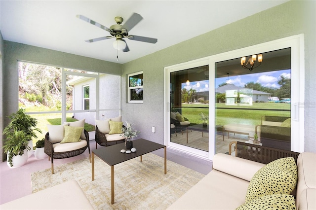 sunroom / solarium with ceiling fan with notable chandelier