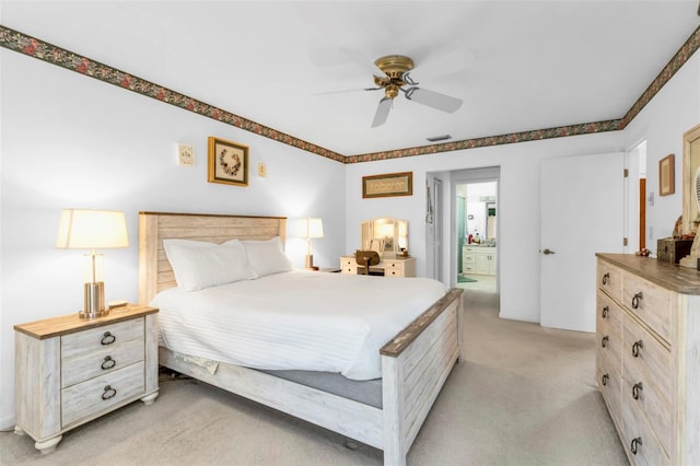 carpeted bedroom featuring ceiling fan and ensuite bathroom