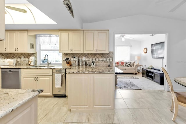 kitchen with lofted ceiling, dishwasher, sink, light stone countertops, and tasteful backsplash