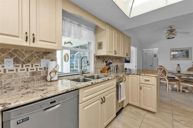 kitchen featuring kitchen peninsula, light stone countertops, stainless steel dishwasher, vaulted ceiling, and sink