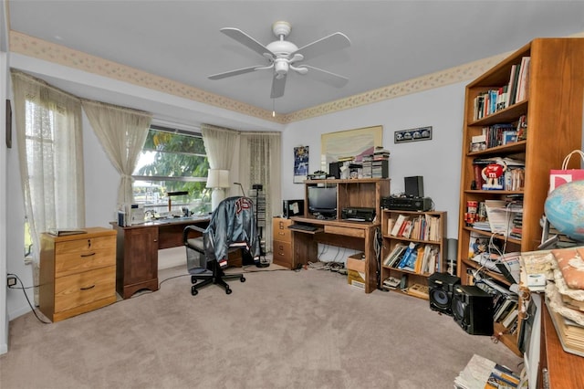 carpeted office space featuring ceiling fan