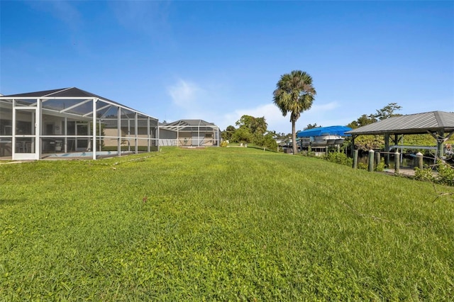 view of yard featuring a gazebo and glass enclosure