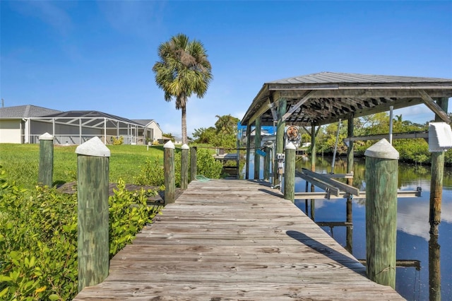 dock area featuring a lanai, a lawn, and a water view