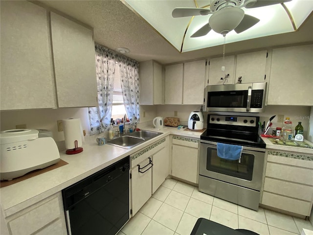 kitchen with sink, a textured ceiling, ceiling fan, stainless steel appliances, and light tile patterned floors