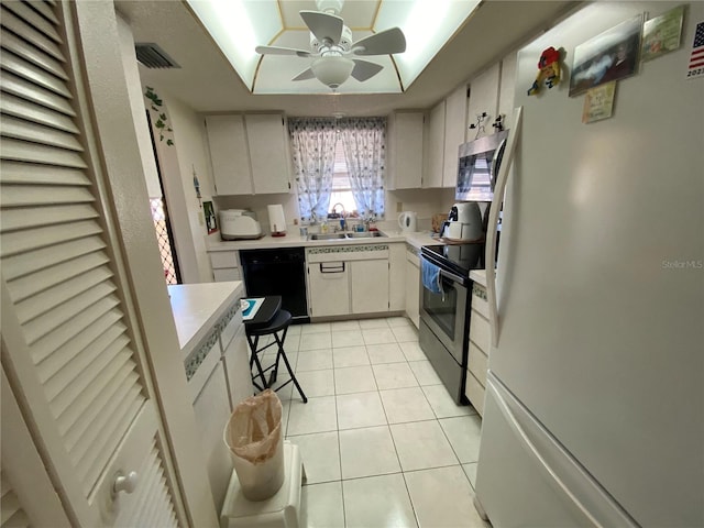 kitchen featuring light tile patterned floors, black appliances, sink, and white cabinets