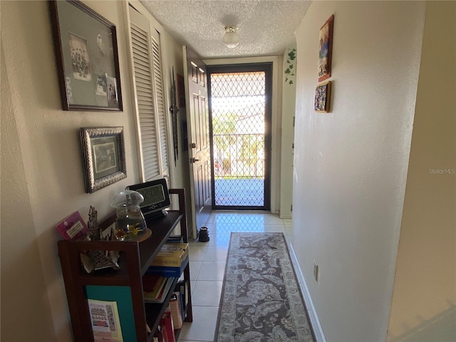 doorway to outside featuring a textured ceiling and light tile patterned floors