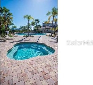 view of pool featuring a community hot tub and a patio