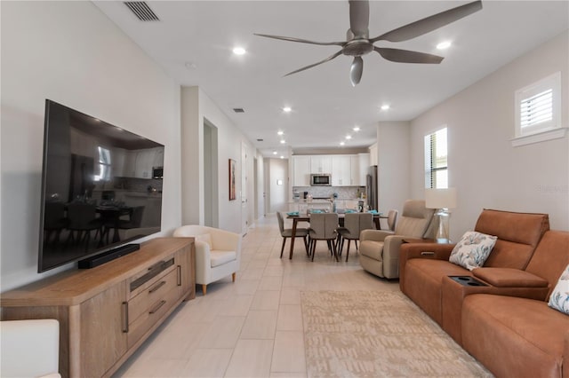 living room featuring ceiling fan and light tile patterned floors