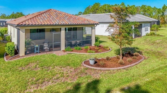 back of house with a yard and a sunroom