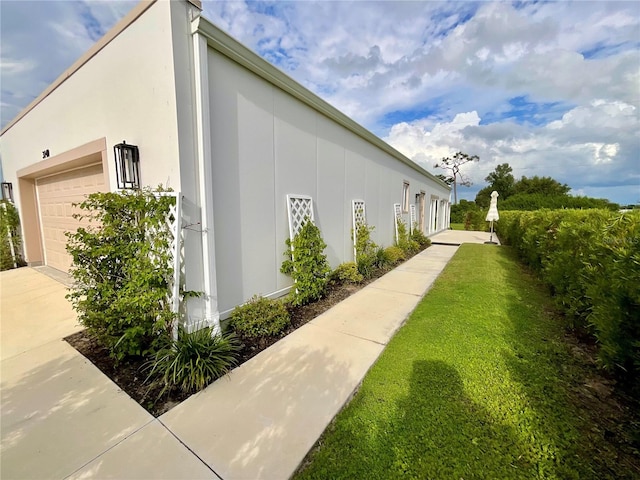 view of home's exterior with a garage and a yard