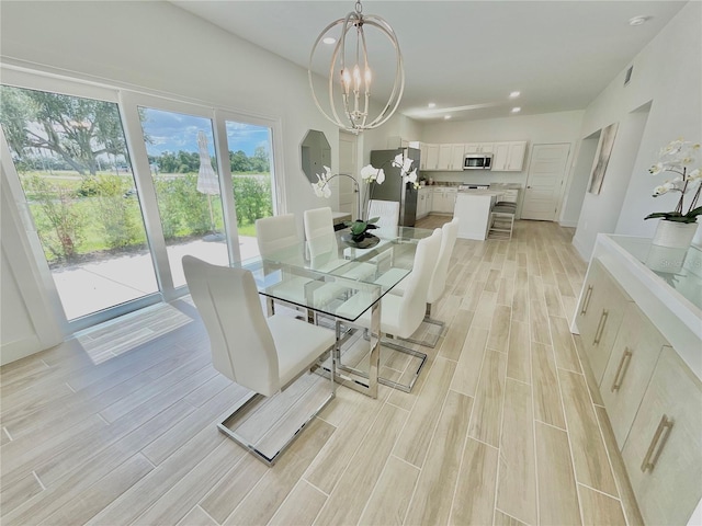 dining area with light hardwood / wood-style floors and a chandelier