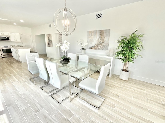 dining space with an inviting chandelier and light wood-type flooring