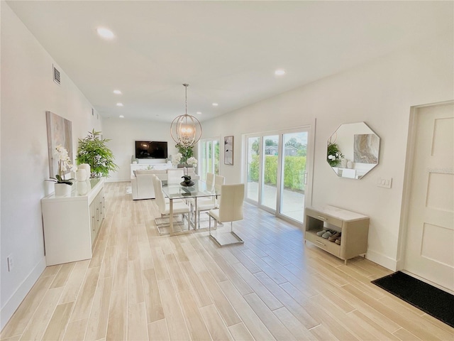 dining room featuring light wood-type flooring and a chandelier