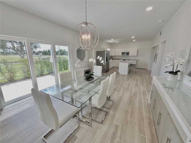 dining space featuring light hardwood / wood-style floors and an inviting chandelier