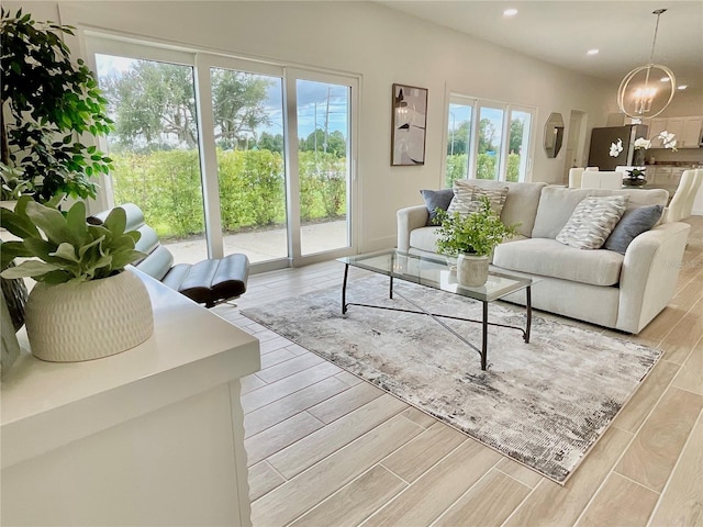 living room with an inviting chandelier and light wood-type flooring