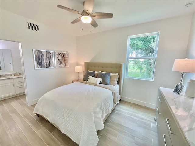 bedroom featuring ensuite bathroom, light hardwood / wood-style flooring, and ceiling fan