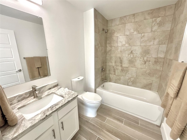 full bathroom with toilet, tiled shower / bath combo, and vanity