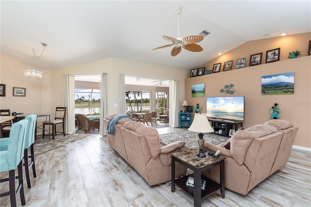 living room featuring lofted ceiling, light hardwood / wood-style flooring, and ceiling fan with notable chandelier