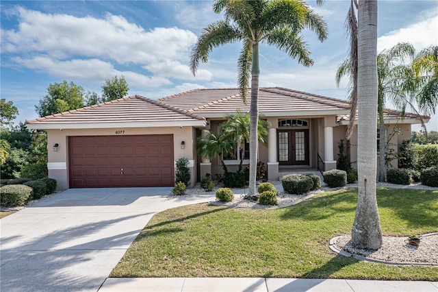 view of front of property with french doors, a front yard, and a garage