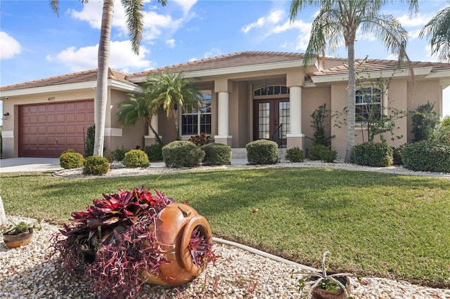 4077 La Costa Island Ct, Punta Gorda, FL 33950 - view of front of home with an attached garage, a tile roof, stucco siding, a front yard, and french doors