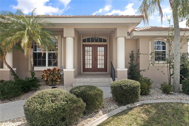 4077 La Costa Island Ct, Punta Gorda, FL 33950 - entrance to property featuring a tiled roof, french doors, and stucco siding