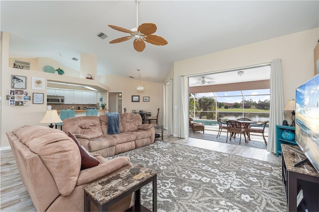 living room with ceiling fan, lofted ceiling, and light wood-type flooring