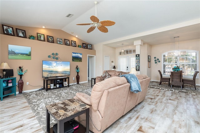 living room with light hardwood / wood-style floors, lofted ceiling, and ceiling fan with notable chandelier