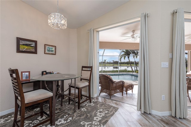 4077 La Costa Island Ct, Punta Gorda, FL 33950 - dining space with an inviting chandelier, a water view, baseboards, and wood finished floors