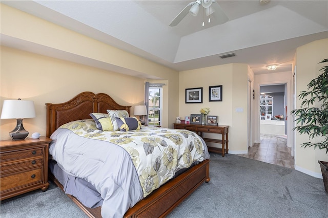 bedroom with ceiling fan, a tray ceiling, and carpet floors